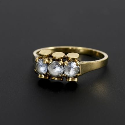 Modernistischer Ring mit 3 hellblauen Farbsteinen.