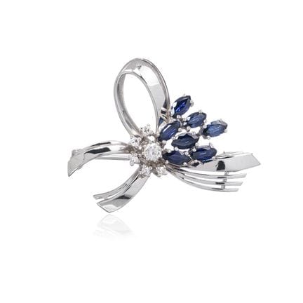 Broche en or blanc en forme de boucle avec des bri