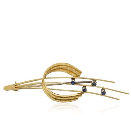 Broche en or queue de comète avec quatre saphirs.
