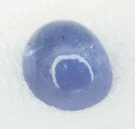 一颗5.08克拉的椭圆形凸面坦桑石。附AIG密封证书。尺寸为10.85 × 8.78 × 5.92 