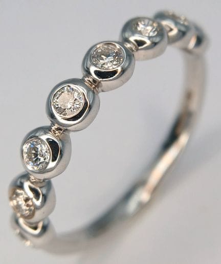 An 18K White Gold and Diamond Half Eternity Ring. 