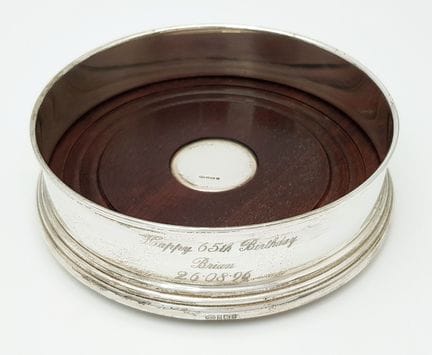 A Sterling Silver and Wood Wine Bottle Coaster. En