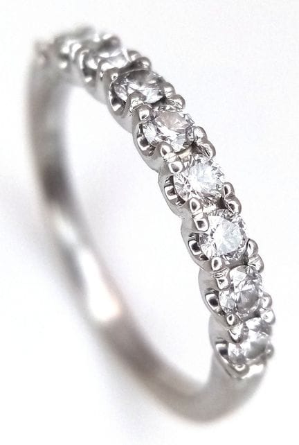 An 18K White Gold and Diamond Half Eternity Ring. 