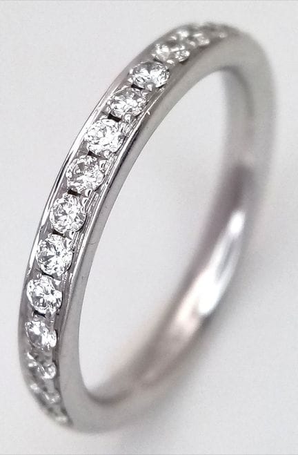 An 18K White Gold and Diamond Half Eternity Ring. 
