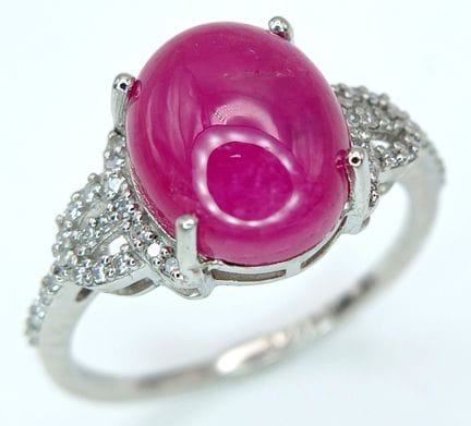 AN EXQUISITE 6.08ct OVAL NATURAL RUBY CABOCHON SET