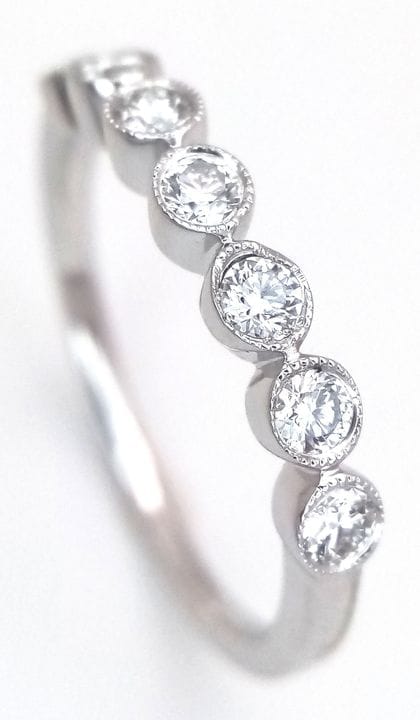 An 18K White Gold and Seven Diamond Stone Ring. 0.