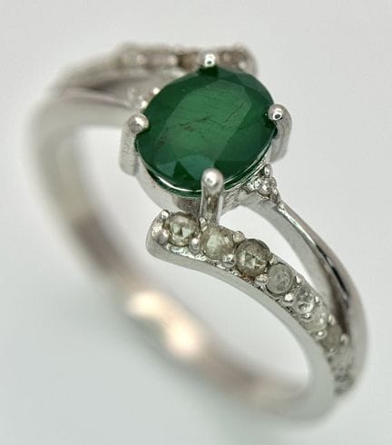 An Emerald and Diamond Crossover Ring. Set in silv