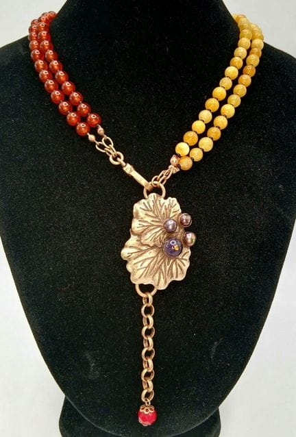 Un llamativo collar con colgante en forma de hoja,