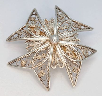 Un broche vintage de filigrana con una cruz de Mal