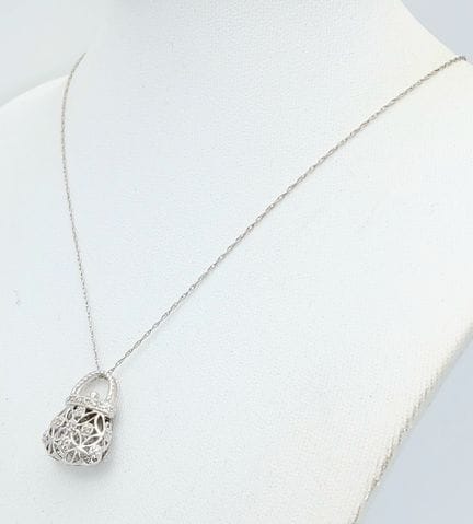 A 9K WHITE GOLD, DIAMOND SET, HANDBAG PENDANT ON A