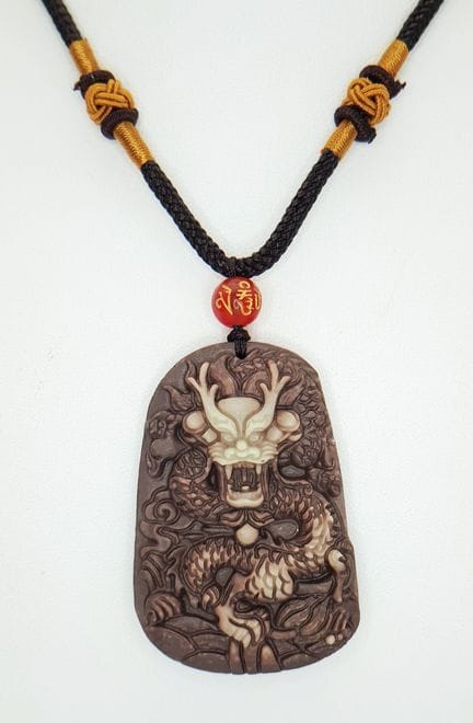 A decorative stone carved pendant with dragon deca