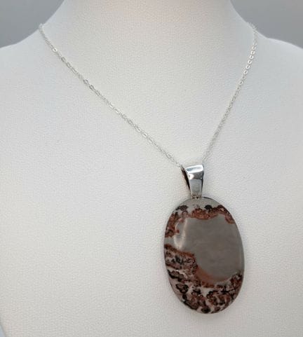 Un pendentif en jaspe monté sur un collier en arge