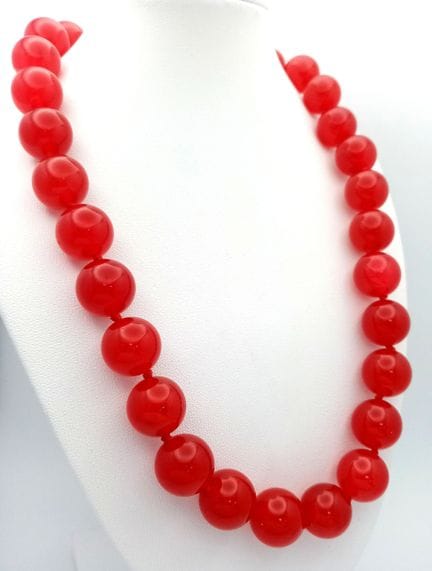 Un collier composé de perles de jade rouge cerise.