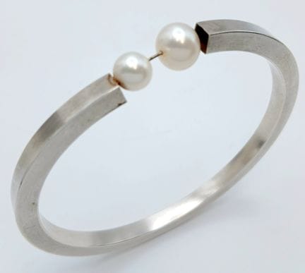 Una elegante pulsera rígida de plata con perlas de