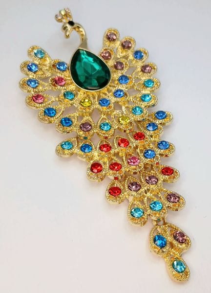 Un gran broche con forma de pavo real, decorado co