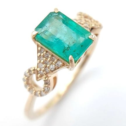 UNE BAGUE EN OR 14 CARATS SERTIE D'UNE ÉMERAUDE NA