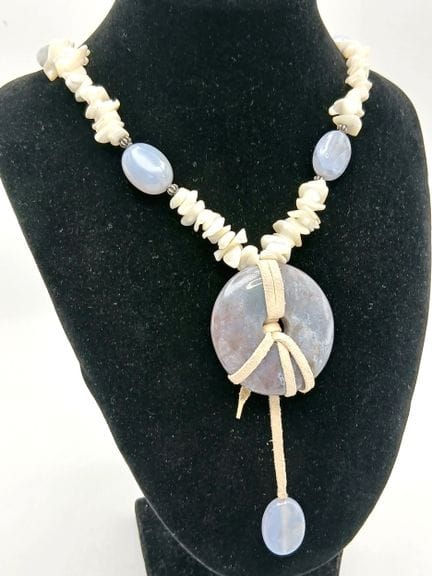 Un llamativo collar con colgante de nácar y calced