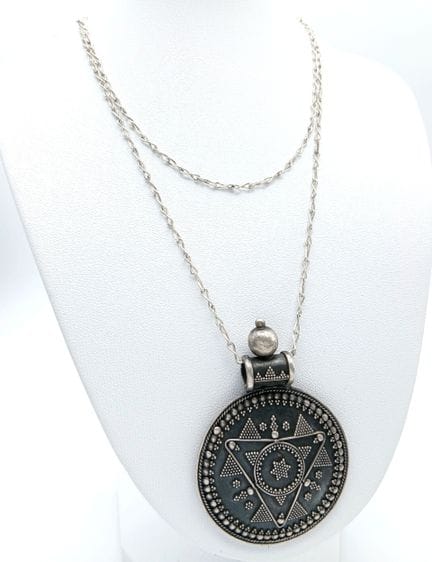 Un llamativo collar con un colgante grande en form