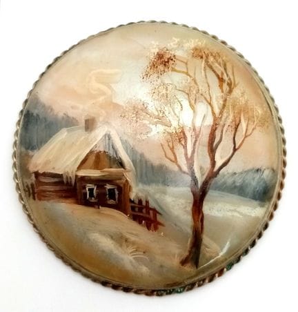 Broche en nacre représentant une scène hivernale.