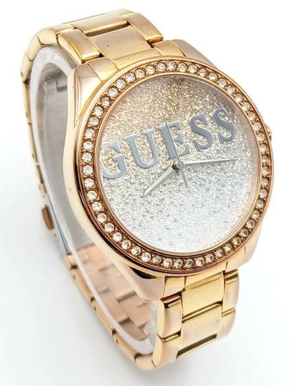 Eine Armbanduhr von GUESS mit Steinen und goldfarb