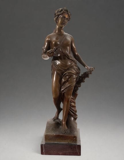 身着垂褶衣裳的古典女性雕像——19世纪
青铜雕塑。48 × 13 × 13 厘米。站立的女性雕像，腰