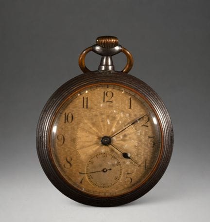 Taschenuhr mit goldenem Zifferblatt
Dunkles Metall
