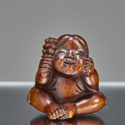 (R) NETSUKE REPRÉSENTANT UN ENFANT ASSIS AVEC UN H