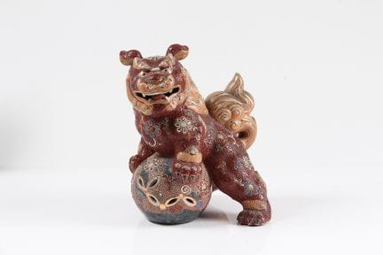 守卫狮。日本。九谷。红釉陶瓷雕像，饰以金彩。高：24 厘米。