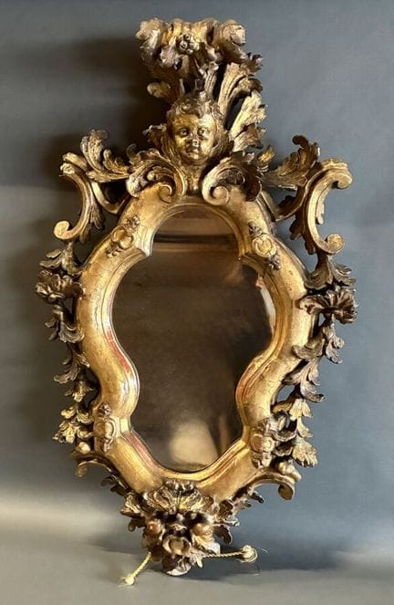 Miroir en bois dorée de forme mouvementé à décor d