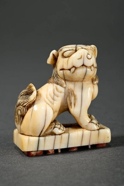 Netsuke en ivoire « Lion gardien », H. 3,7 cm, fis