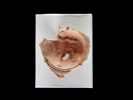 Fragmento de una lámpara de aceite romana
Con pean