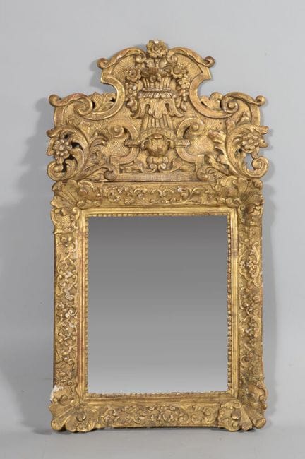 Carved gilded wooden mirror; the pediment is decor
