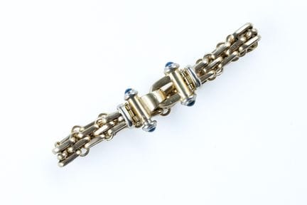 18K（750）黄金与灰金混合材质手链，采用米粒纹链节设计，配有镶嵌蓝宝石凸圆面宝石的宽大圆柱形搭扣