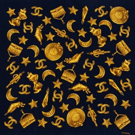 CHANEL. 
Silk scarf with gold charms on a navy blu