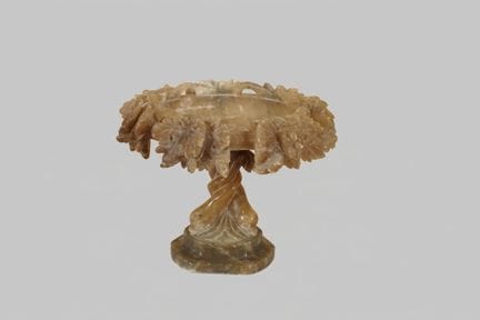 Alabaster bowl; the base is decorated with dolphin