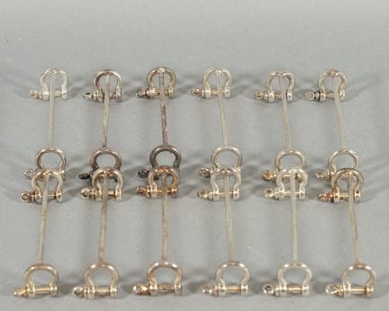 12 silver plated metal knife holders with a shackl