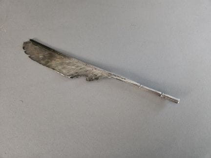 Porte-plume en forme de plume d'oiseau en argent.
