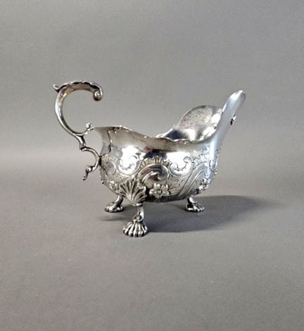 Saucière casque tripode en argent à décors de volu