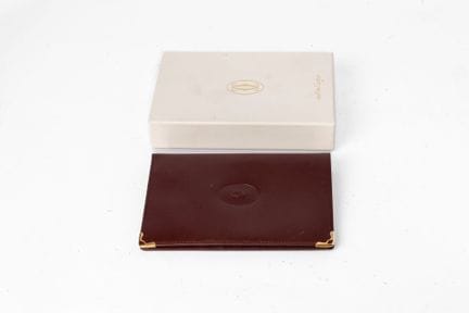 卡地亚（CARTIER）经典款
小牛皮与镀金金属材质的卡包。
表面压印有椭圆形品牌首字母标识。
高1