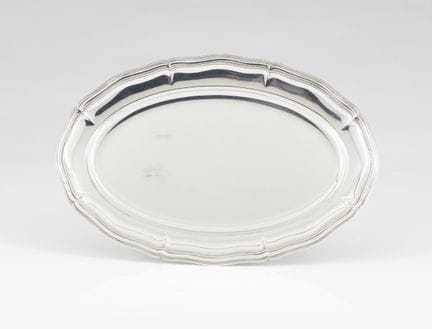Una bandeja plateada
Metal plateado
Borde festonea