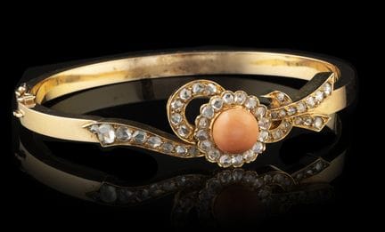 Un brazalete de oro con coral y diamantes
Oro, ley
