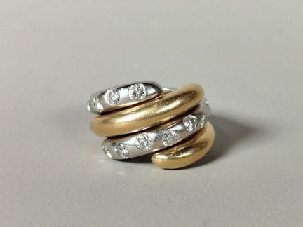两枚可套叠的蛇形戒指，均由18K 750黄金和白金制成，每枚均镌有鹰头印记，呈现双圈缠绕造型，两端呈
