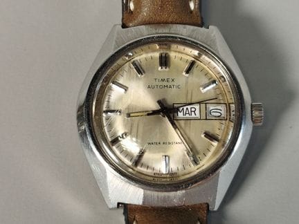 TIMEX：自动上链机械机芯腕表，金属枕形表壳，香槟色表盘配棒形时标，三点钟位置设星期和日期窗口，搭