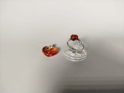 一套由925银制成的戒指，镶嵌一颗心形琥珀凸面宝石，以及一个由类似材质制成的心形吊坠（指围56，总毛
