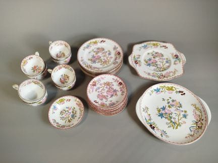 MINTON：一套瓷质餐具，饰有中国风的多色鸟类与花枝图案，边缘采用锯齿形镂空装饰，配以粉色带饰和金