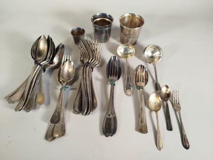 一套由不同款式组成的镀银的金属餐具及服务用具组合，主要包括叉子、勺子、服务用勺、一把撒粉勺和三个汤碗