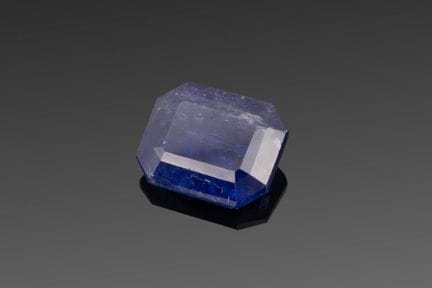 Emerald-cut Tanzanite on paper.
Accompanied by an 