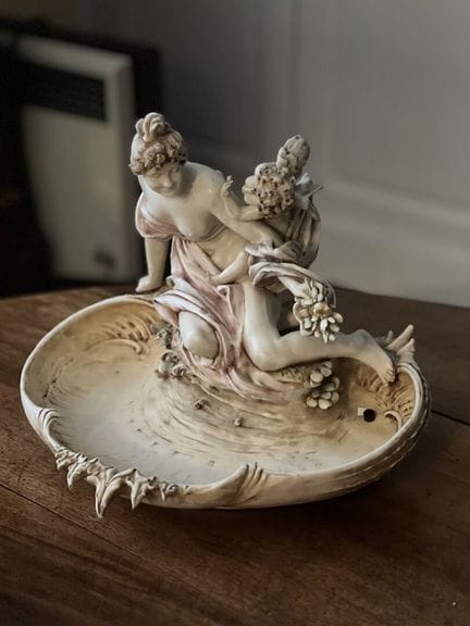 ROYAL WORCESTER，约1900年
釉面瓷制小摆件，描绘了一位身披长袍的女子，正坐在多叶形