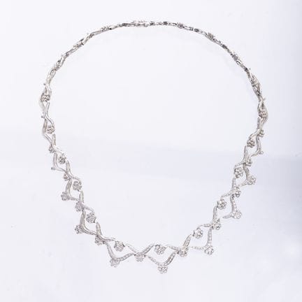 白金镂空“花朵”造型项链，中央部分完全镶嵌明亮式切割钻石。配有双重安全扣。总重42克。