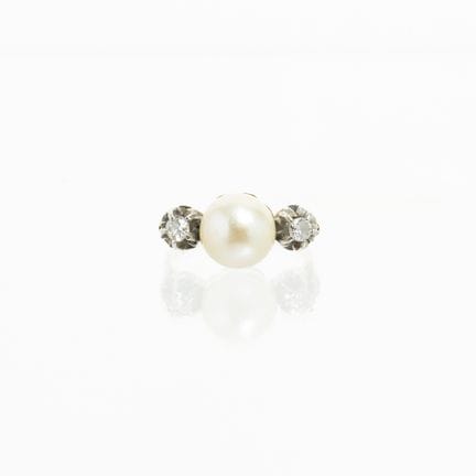 18K黄金戒指，镶嵌一颗直径9毫米的养殖珍珠，两侧各镶嵌一颗明亮式切割钻石，钻石底座为18K白金。内